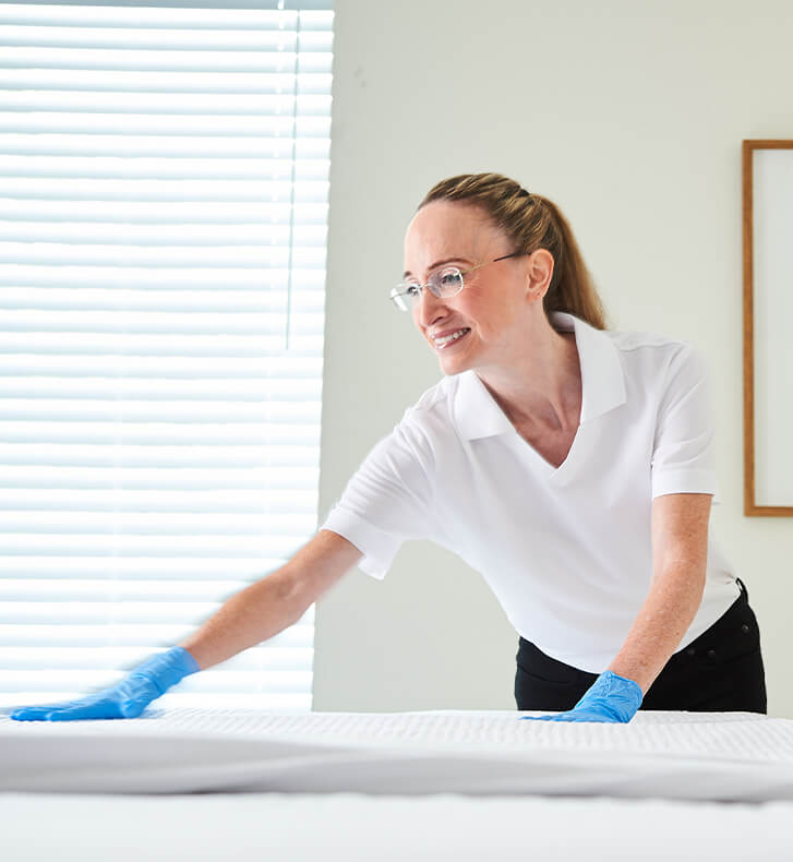 Healthcare worker changing bed sheets