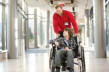 Man pushing a person in a wheelchair