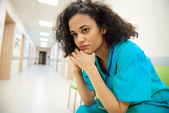 female nurse sitting on a chair with a concerned expression